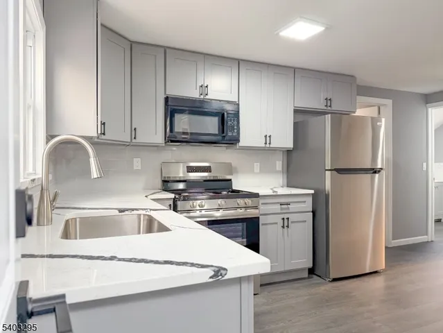 a kitchen with cabinets stainless steel appliances and a sink