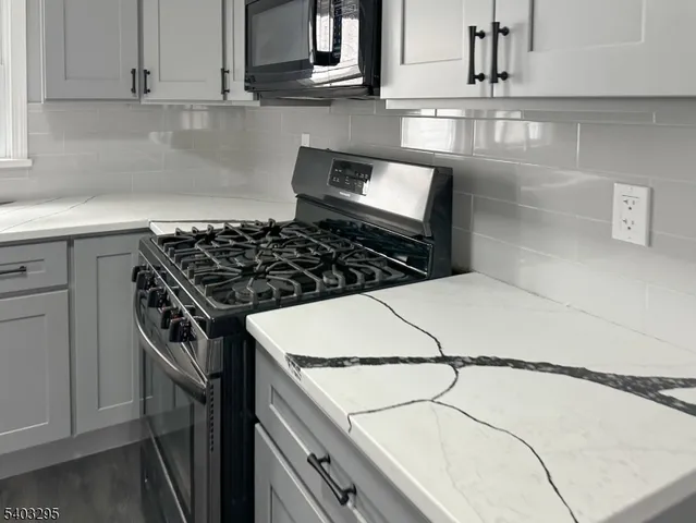 a kitchen with a stove a microwave and cabinets