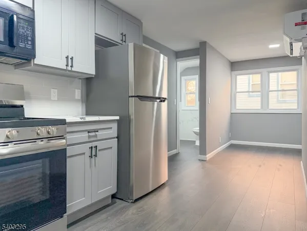 a kitchen with stainless steel appliances granite countertop a refrigerator sink and wooden cabinets