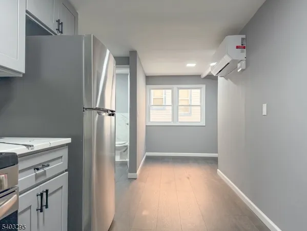 a view of a kitchen with a refrigerator and window