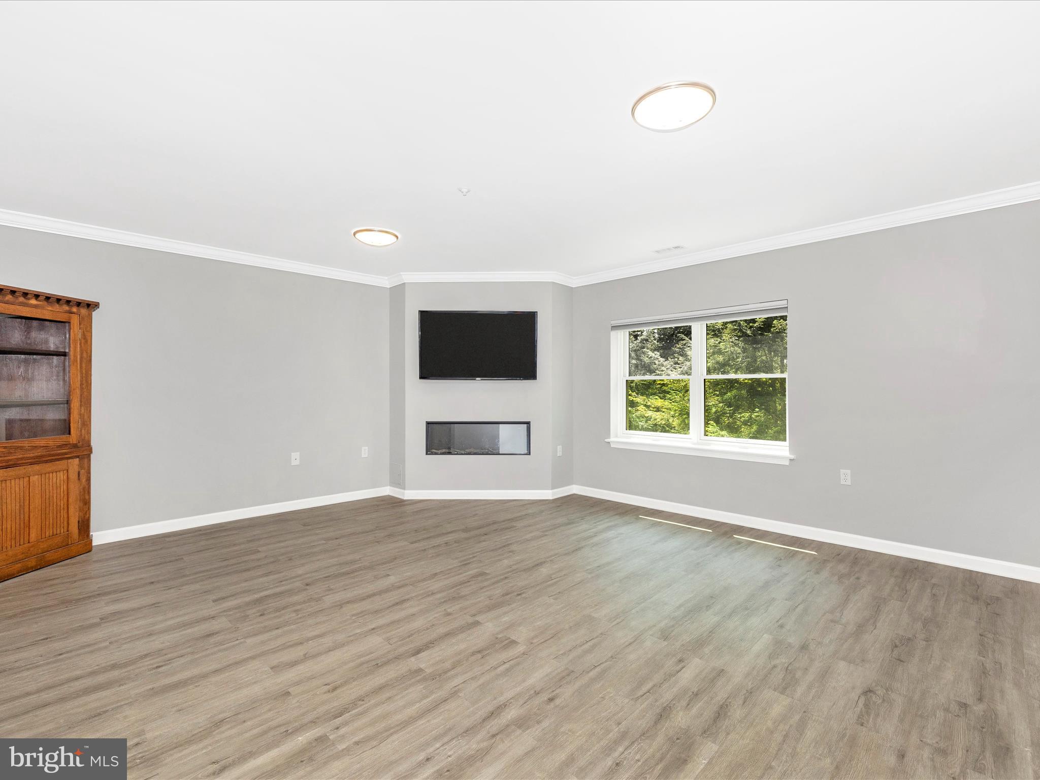 102 Mercer Court, Unit 22 1A Frederick, MD 21701 - Photo 12 of 56 an empty room with wooden floor and windows
