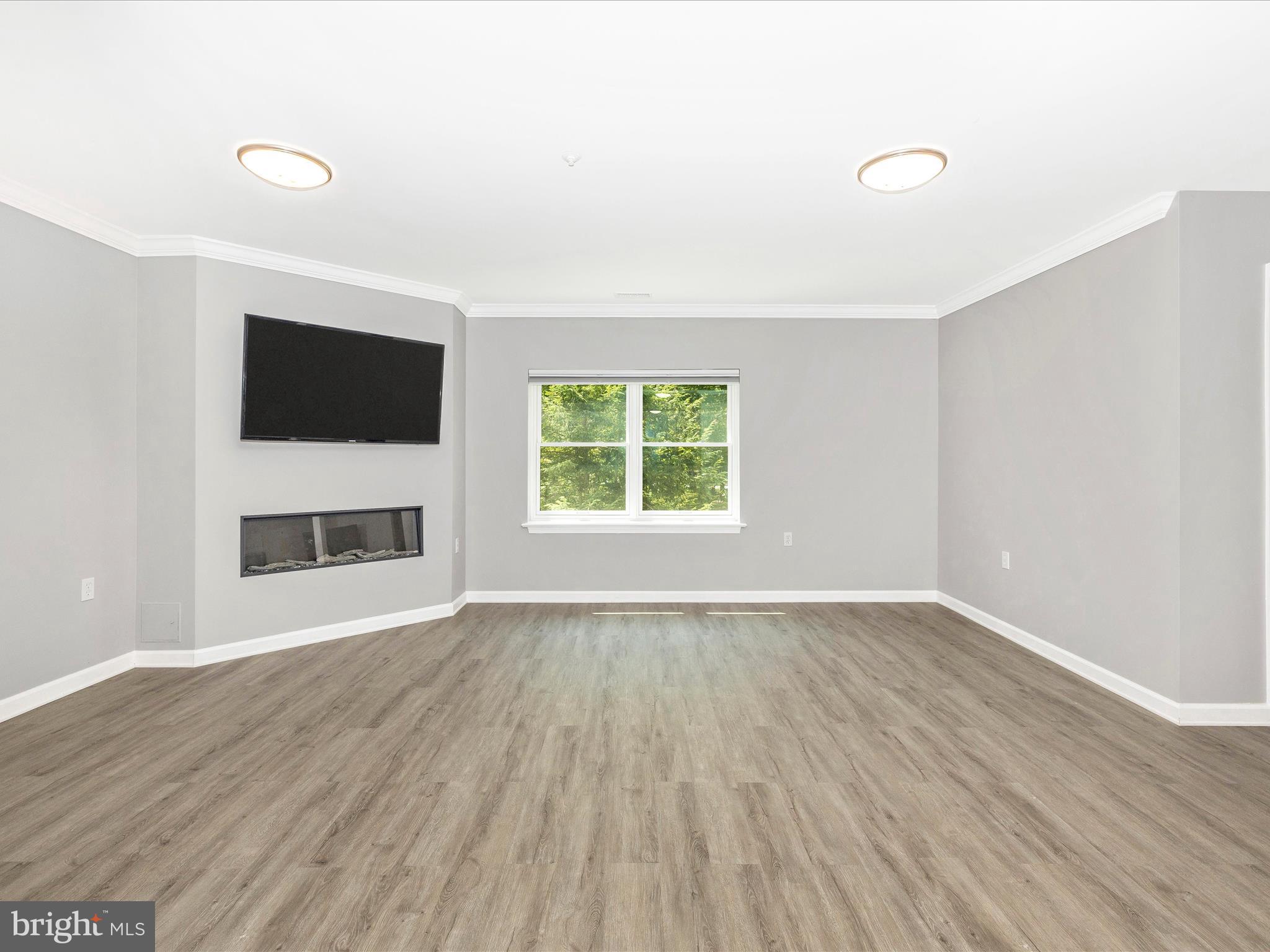102 Mercer Court, Unit 22 1A Frederick, MD 21701 - Photo 13 of 56 an empty room with wooden floor and windows