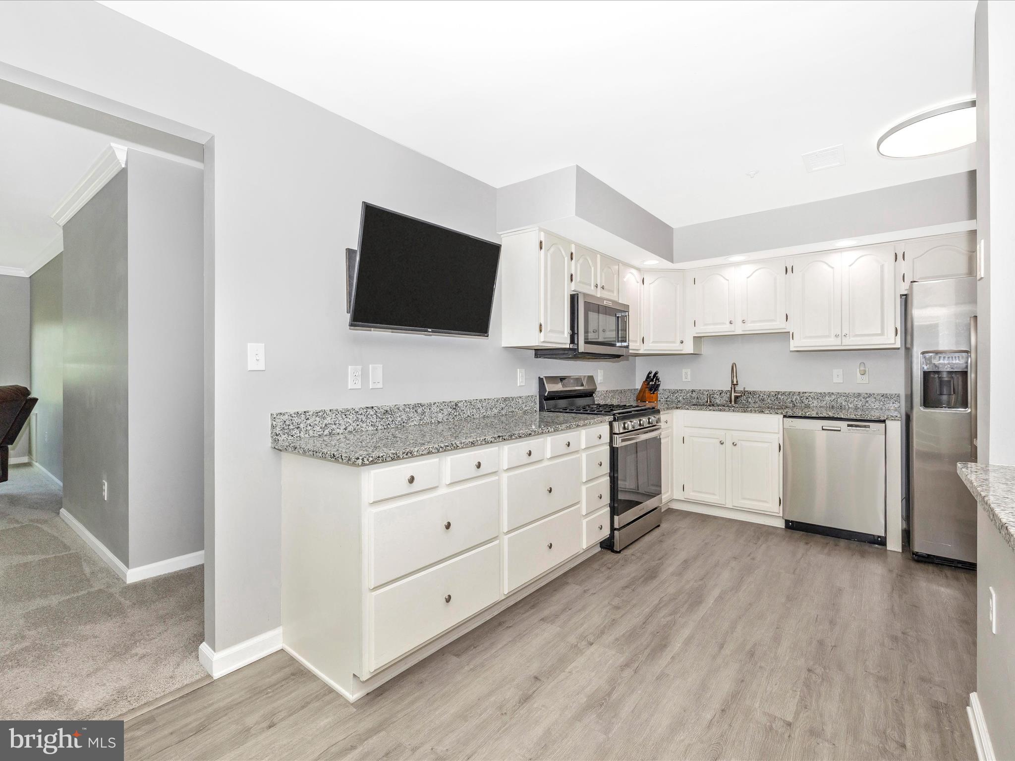 102 Mercer Court, Unit 22 1A Frederick, MD 21701 - Photo 17 of 56 a kitchen with granite countertop white cabinets and white appliances