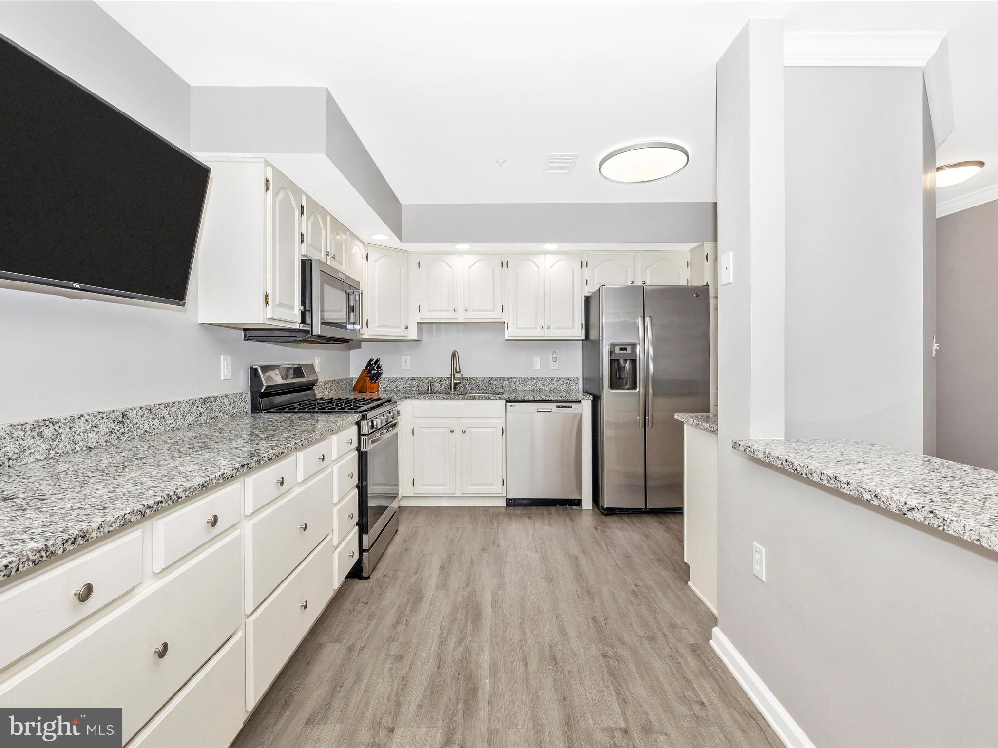 102 Mercer Court, Unit 22 1A Frederick, MD 21701 - Photo 18 of 56 a kitchen with stainless steel appliances granite countertop a stove a sink and a refrigerator