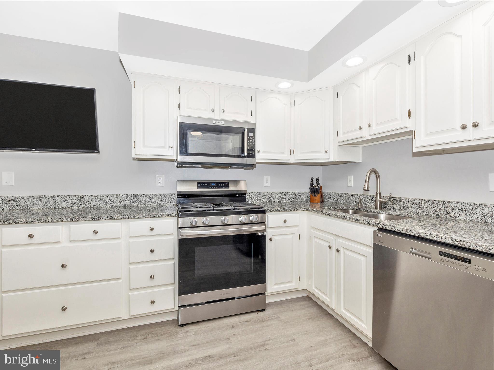 102 Mercer Court, Unit 22 1A Frederick, MD 21701 - Photo 19 of 56 a kitchen with granite countertop white cabinets sink and stainless steel appliances