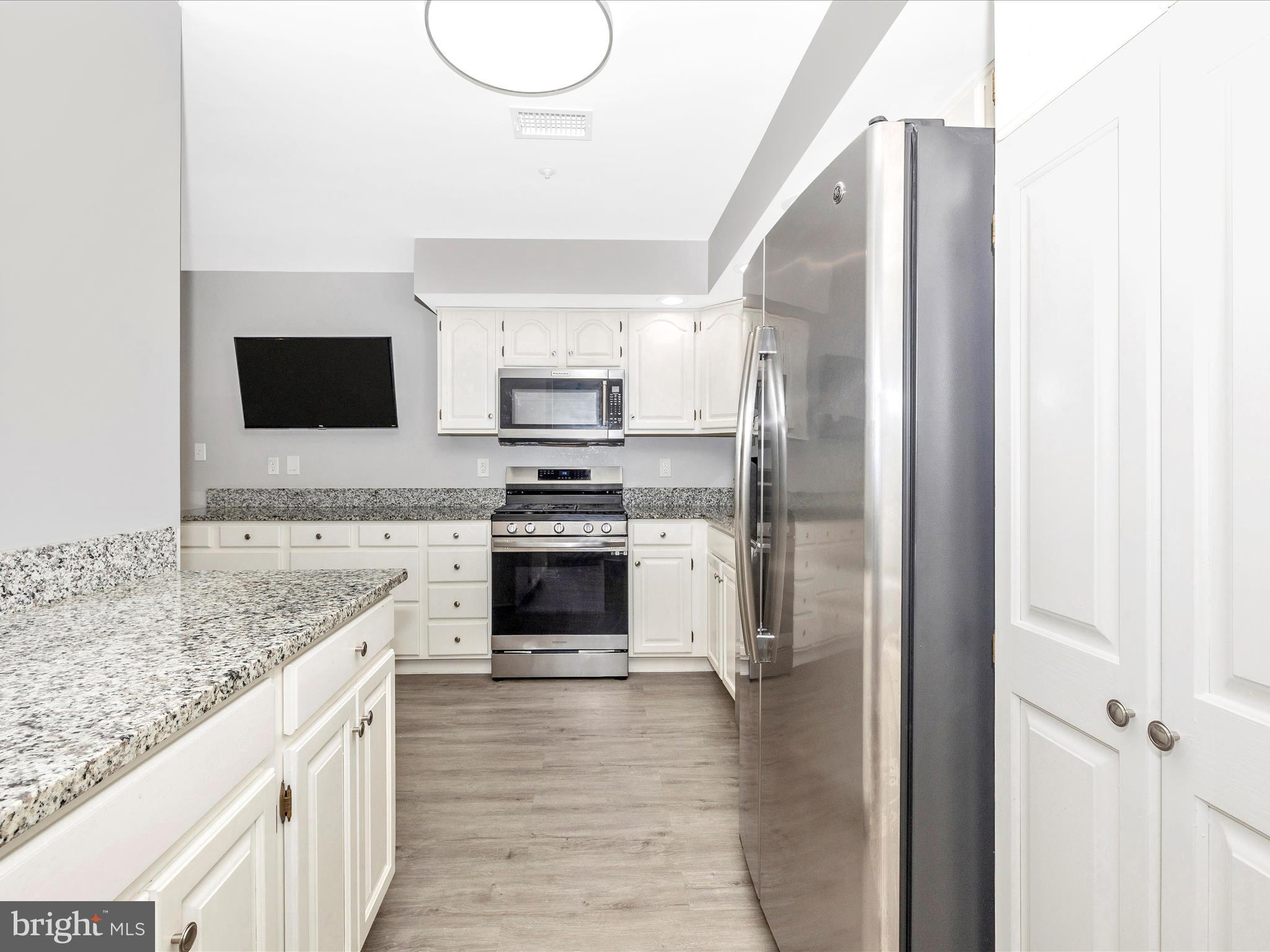 102 Mercer Court, Unit 22 1A Frederick, MD 21701 - Photo 21 of 56 a kitchen with kitchen island granite countertop a stove and a sink