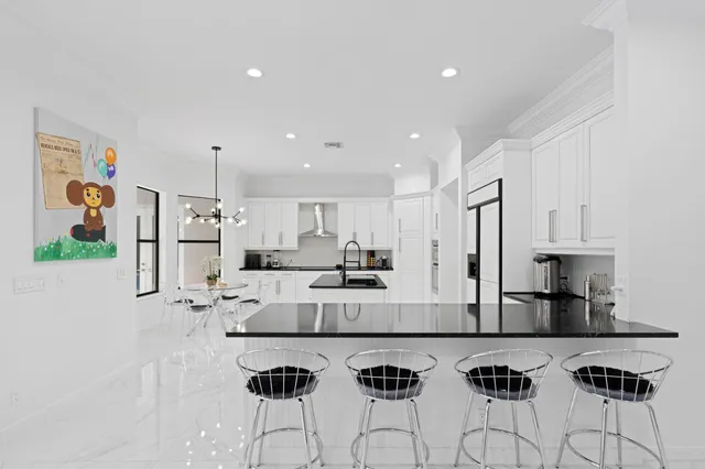 a kitchen with stainless steel appliances kitchen island granite countertop a refrigerator and a stove top oven