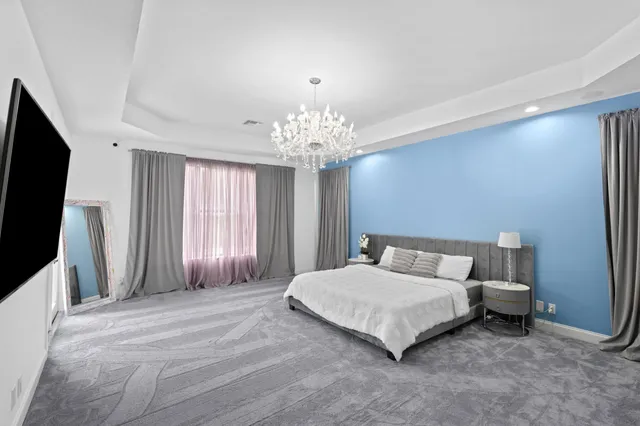 a bedroom with a bed and a chandelier