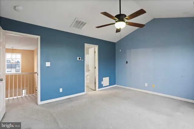 a view of an empty room with a ceiling fan