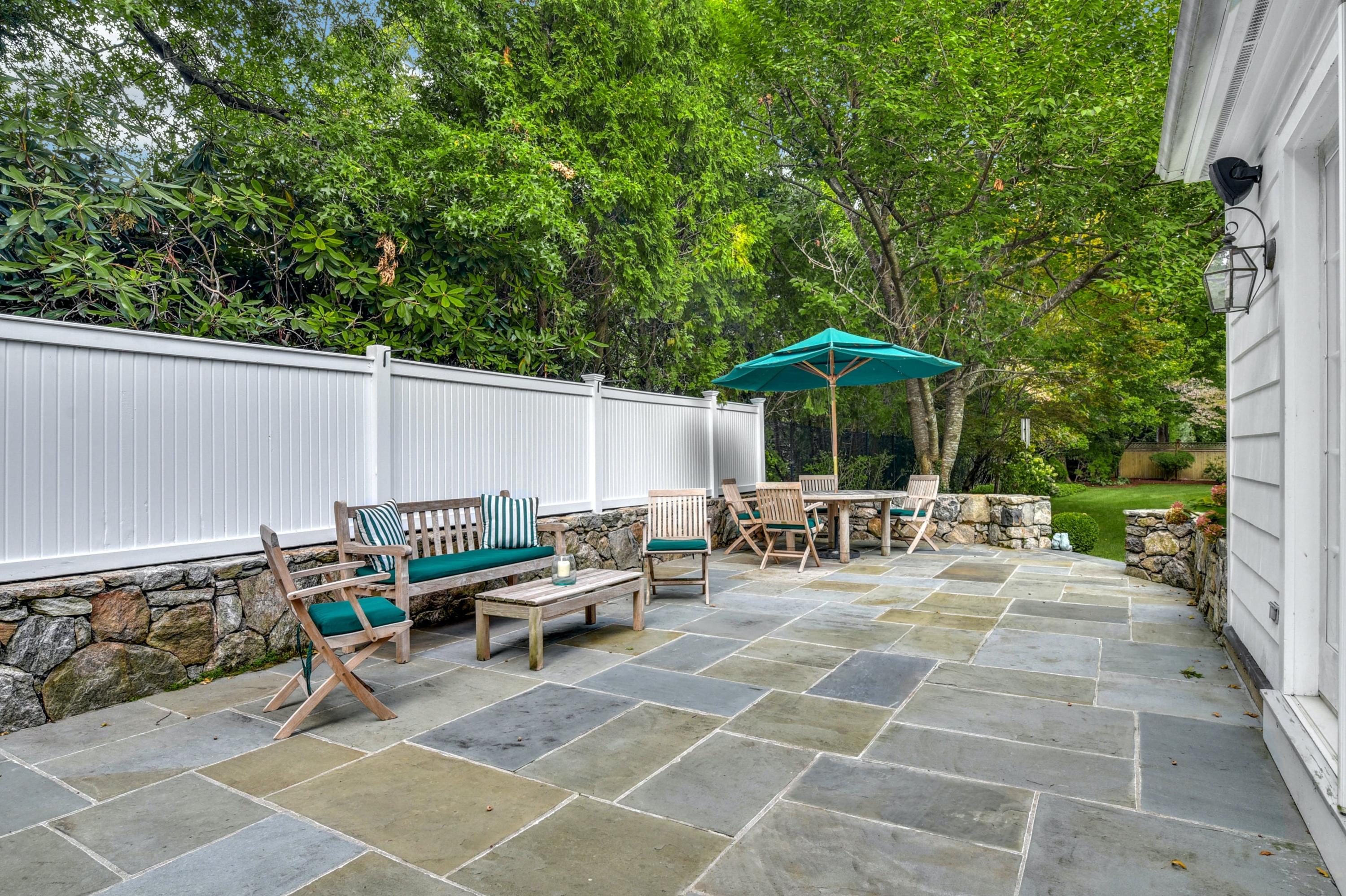 11 Sunset Road Darien, CT 06820 - Photo 31 of 38 a view of the patio with dining table and chairs under an umbrella with a small yard