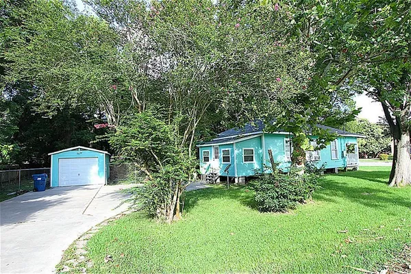 a front view of a house with a yard and trees