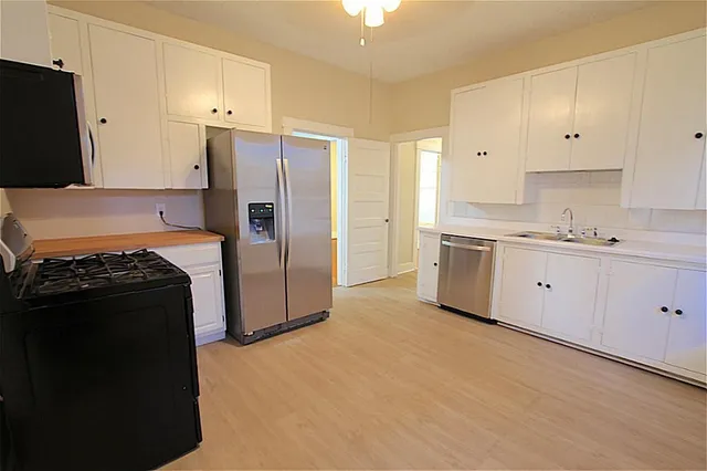 a kitchen with stainless steel appliances granite countertop a refrigerator and a stove