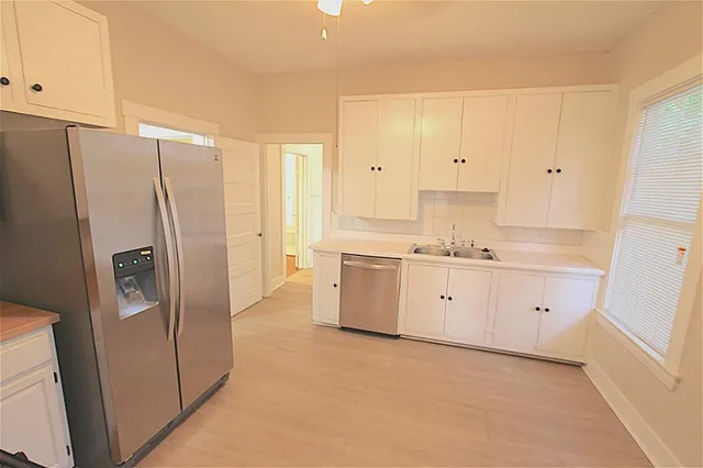 a kitchen with white cabinets white stainless steel appliances and sink