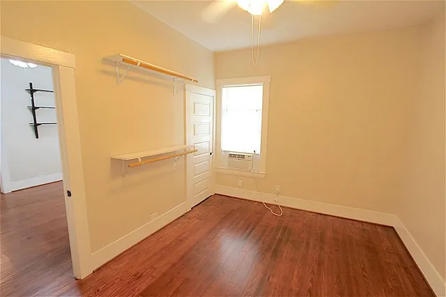 an empty room with wooden floor and a window