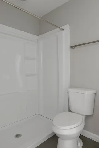 a white toilet sitting next to a bath tub
