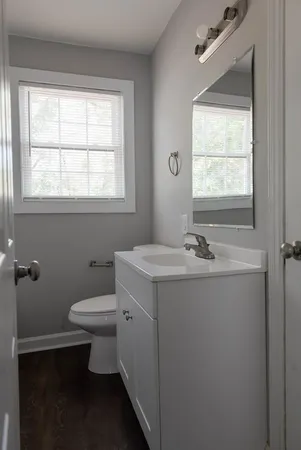a bathroom with a sink toilet and window