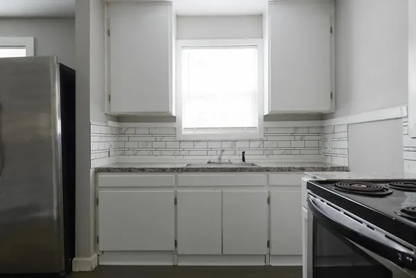 a kitchen with stainless steel appliances granite countertop a sink stove and refrigerator