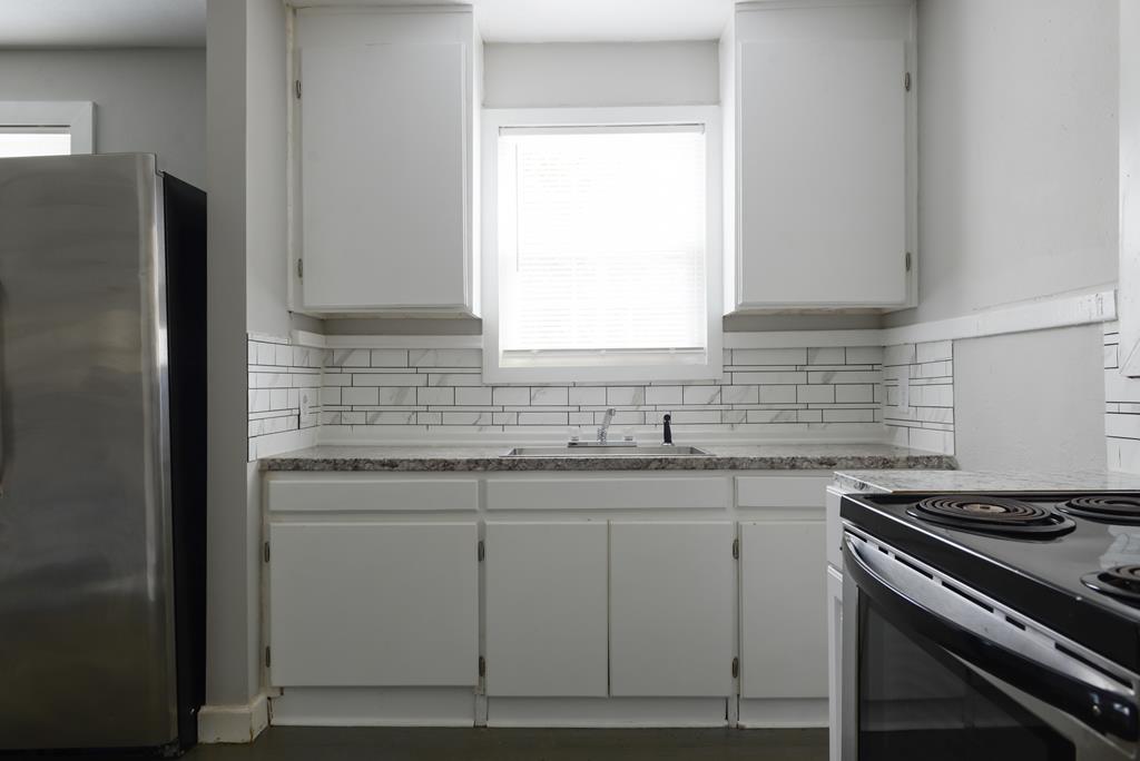 3221 Walker Street Columbus, GA 31903 - Photo 3 of 18 a kitchen with stainless steel appliances granite countertop a sink stove and refrigerator