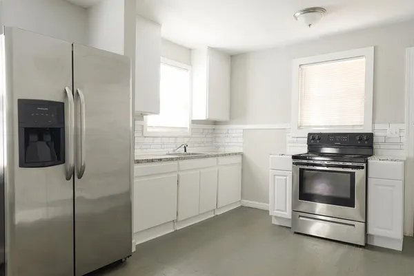 a kitchen with cabinets appliances and a window