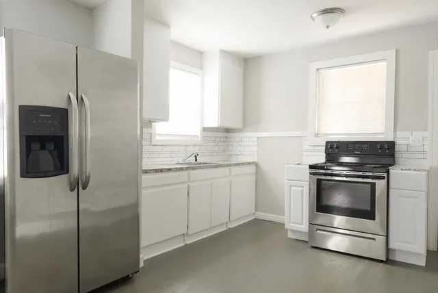 a kitchen with cabinets appliances and a window