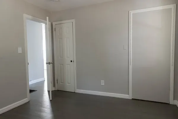 a view of an empty room with wooden floor