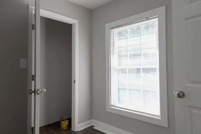 a view of an empty room with closet and a window