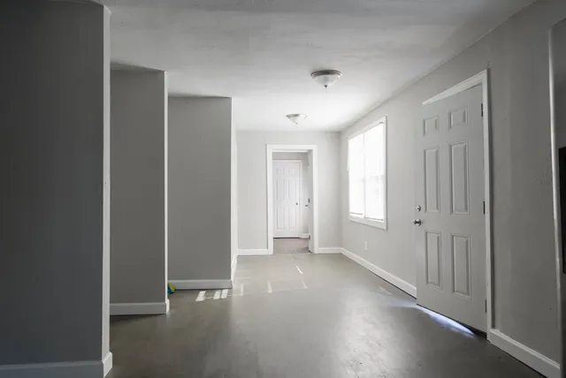 a view of empty room with wooden floor
