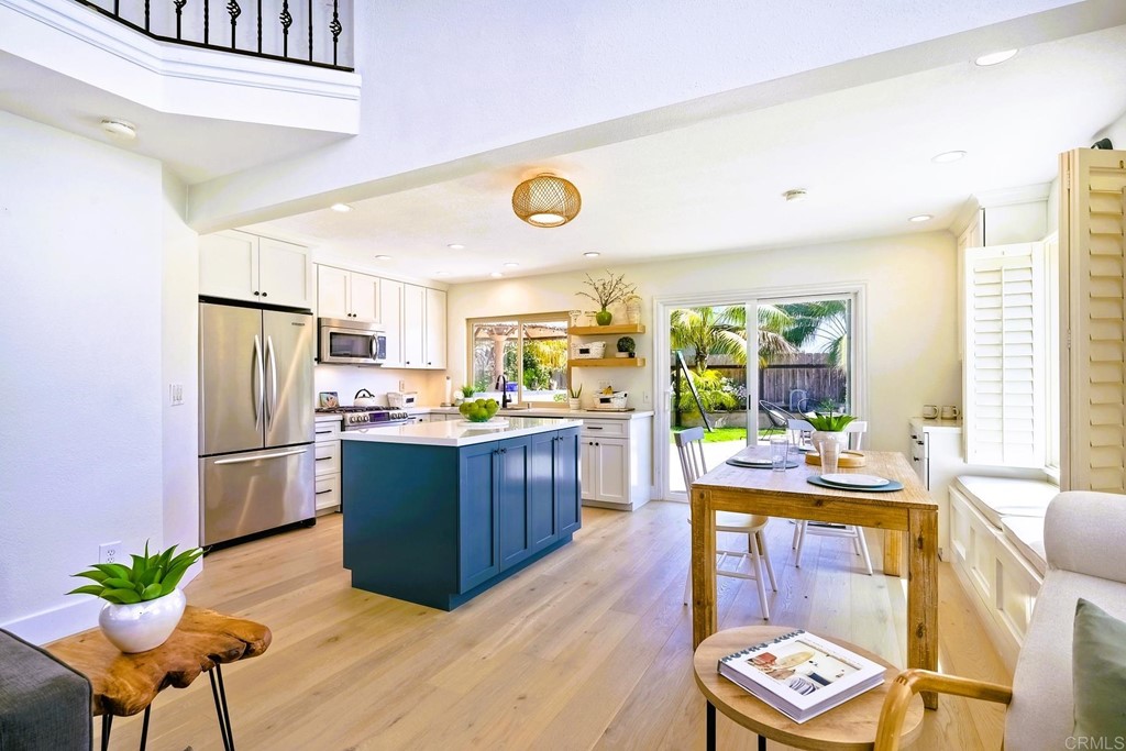 821 Windcrest Drive Carlsbad, CA 92011 - Photo 13 of 53 a kitchen with stainless steel appliances wooden floor and dining table