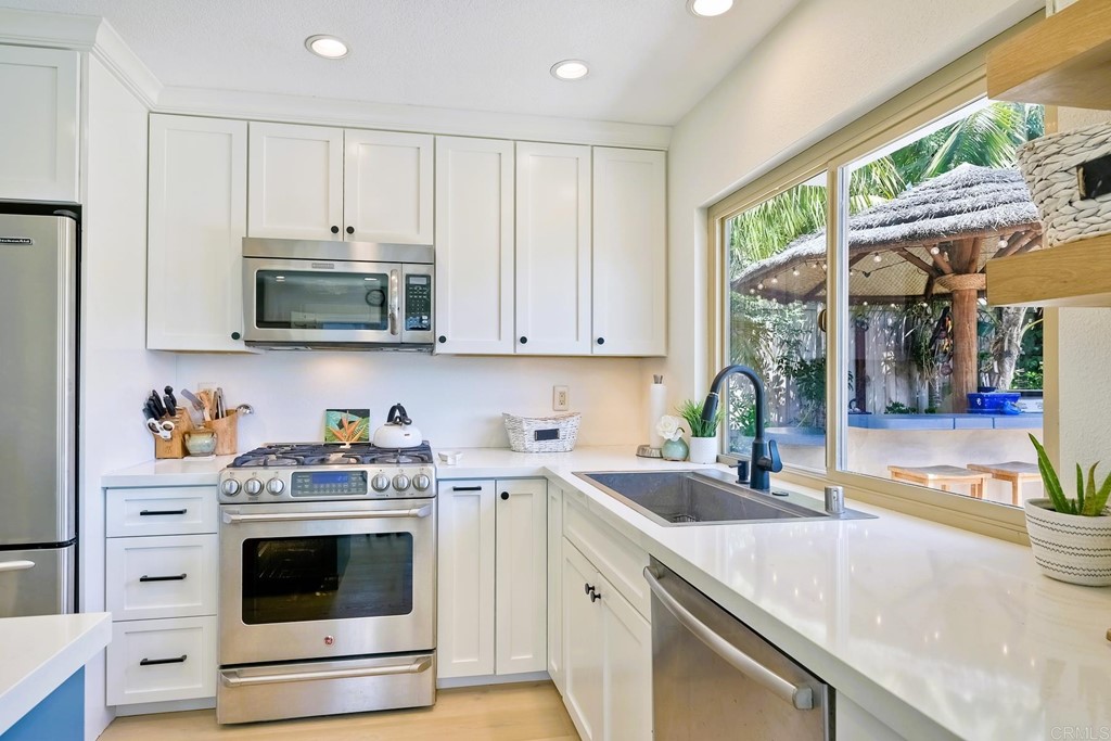821 Windcrest Drive Carlsbad, CA 92011 - Photo 16 of 53 a kitchen with stainless steel appliances a stove a sink a microwave and cabinets