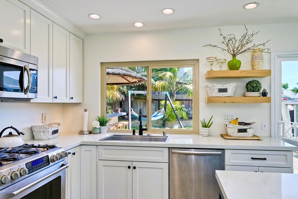 821 Windcrest Drive Carlsbad, CA 92011 - Photo 17 of 53 a kitchen with stainless steel appliances a sink a window and cabinets