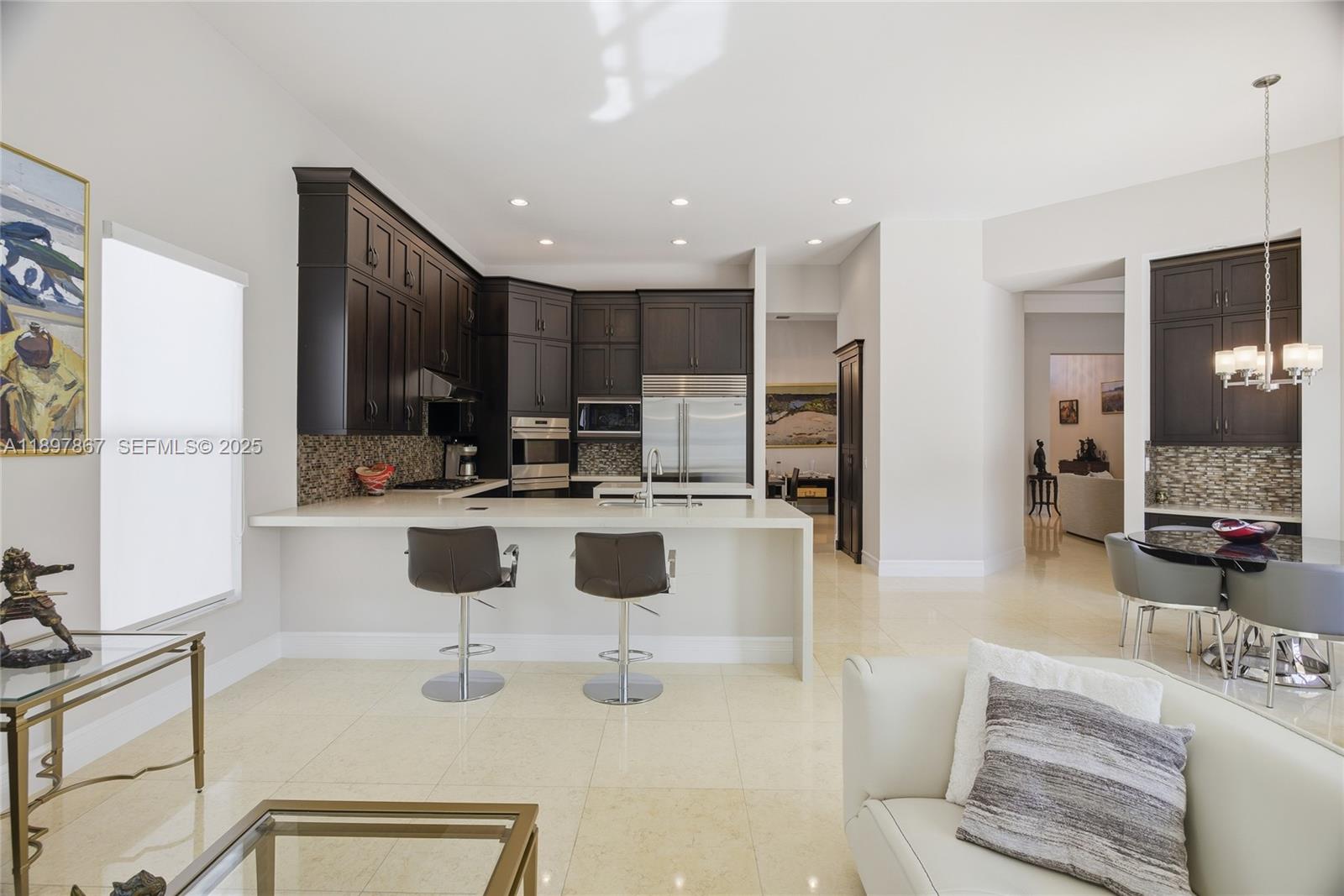 9772 Rennes Lane Delray Beach, FL 33446 - Photo 17 of 59 a kitchen with stainless steel appliances kitchen island granite countertop a refrigerator and a sink