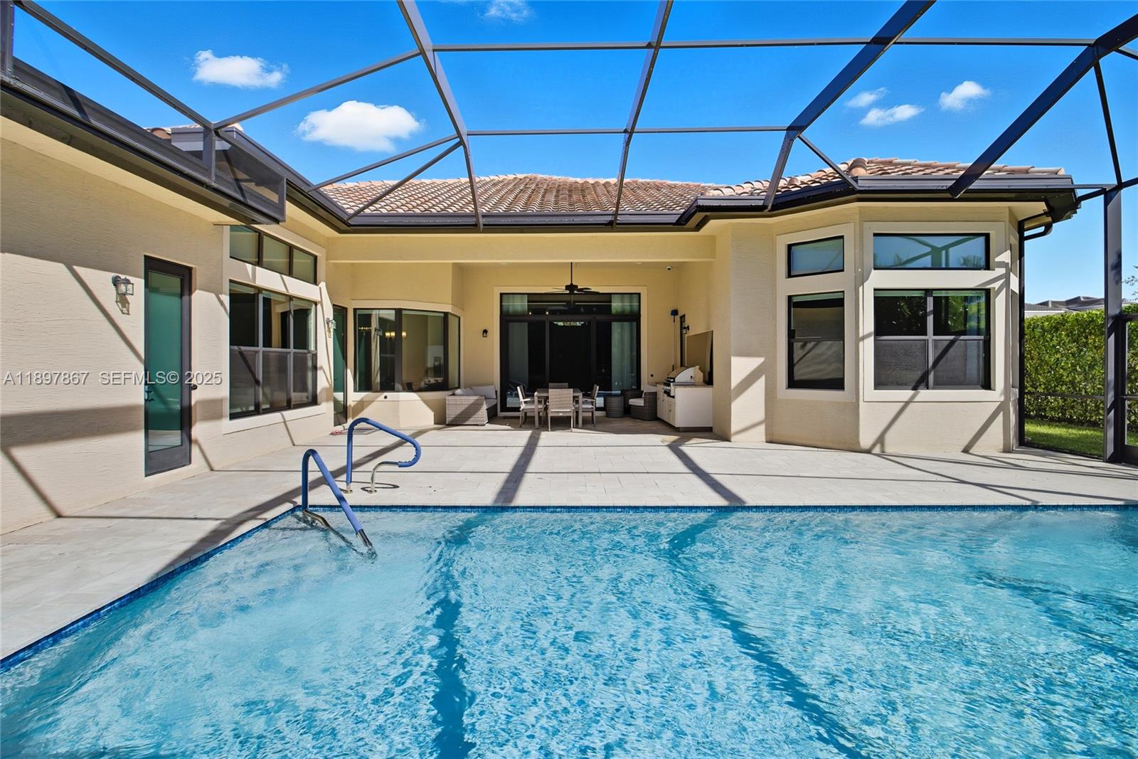 9772 Rennes Lane Delray Beach, FL 33446 - Photo 26 of 59 a view of a patio with table and chairs under an umbrella