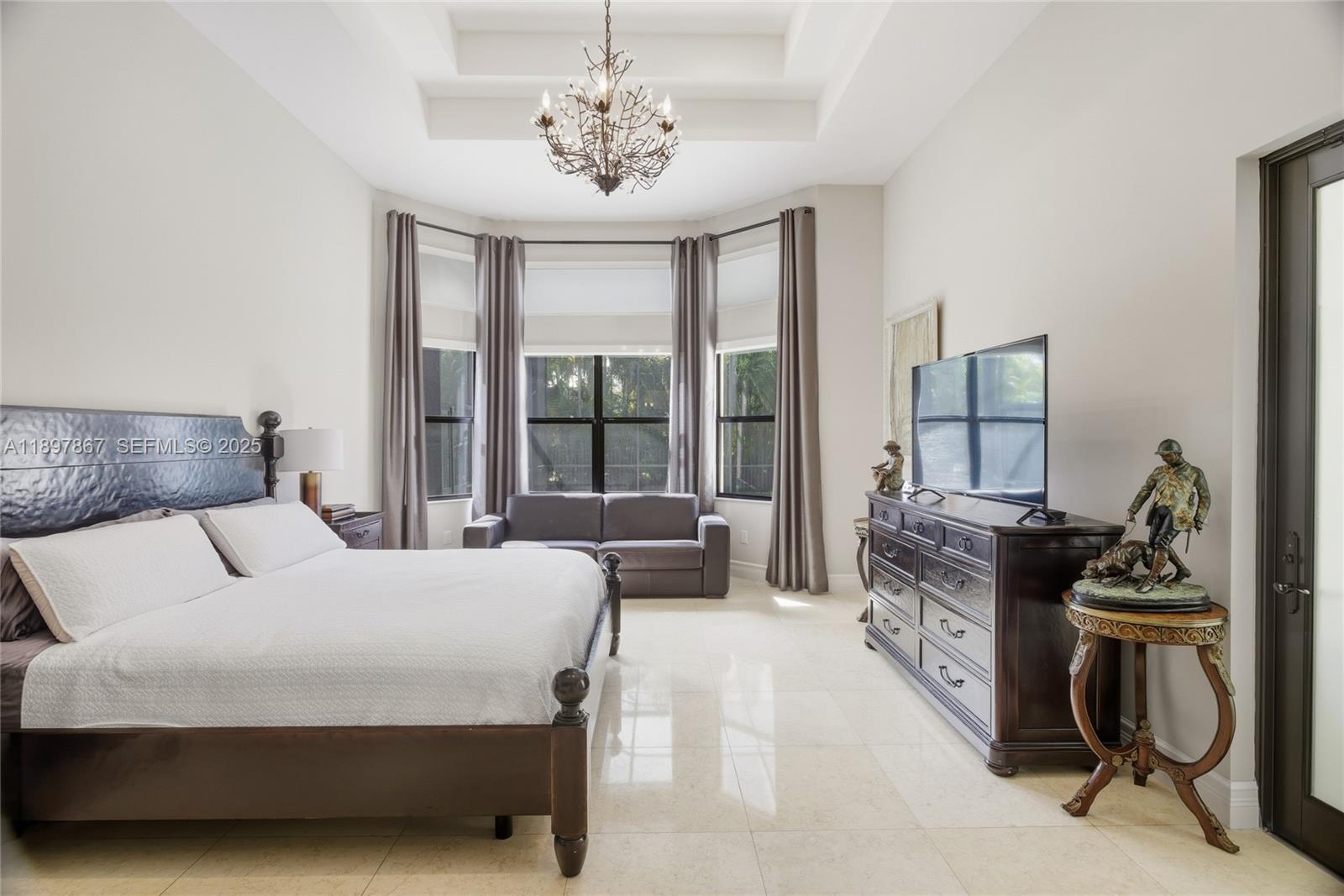 9772 Rennes Lane Delray Beach, FL 33446 - Photo 30 of 59 a bedroom with a bed and a chandelier