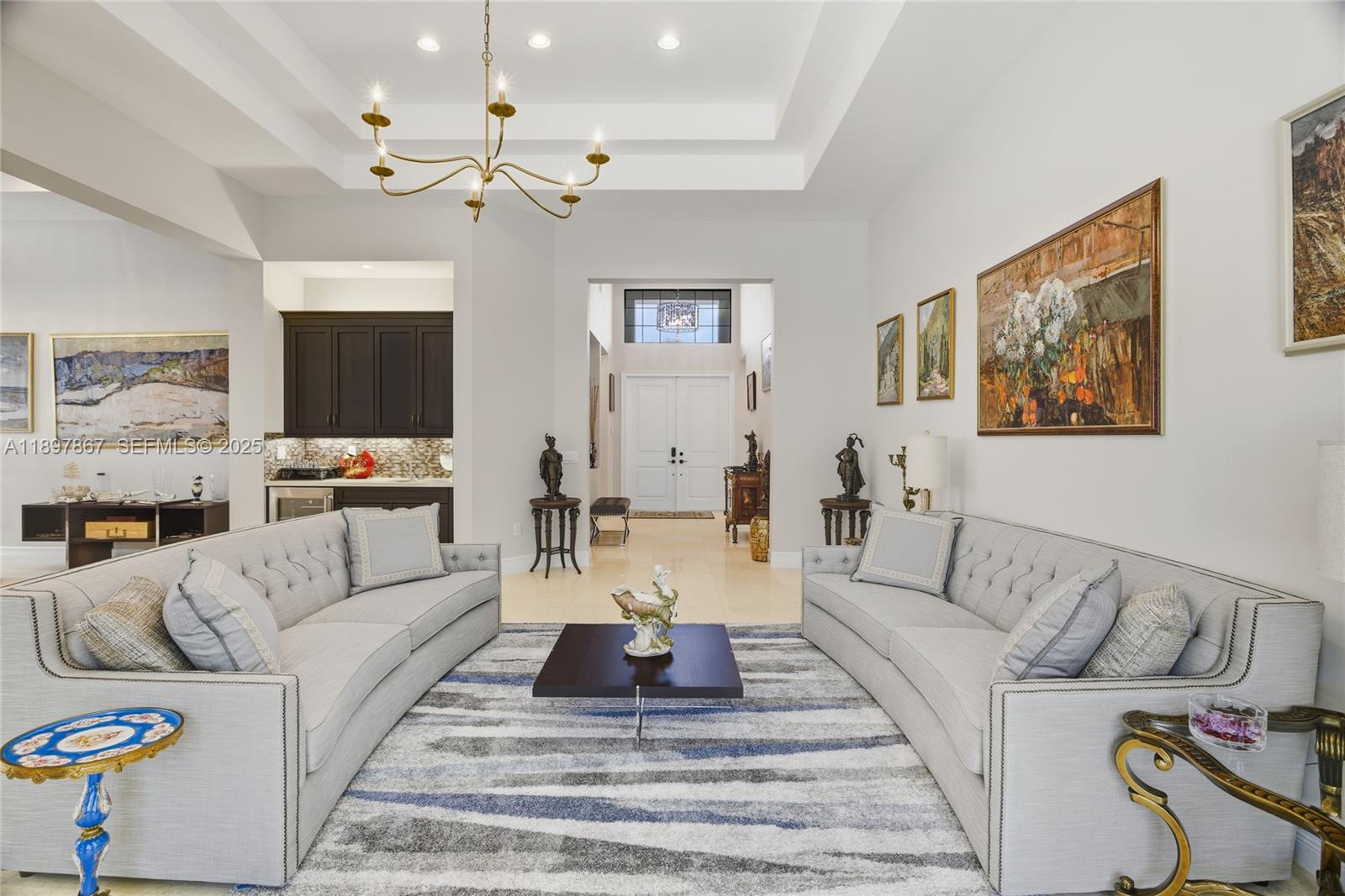 9772 Rennes Lane Delray Beach, FL 33446 - Photo 6 of 59 a living room with furniture and a chandelier
