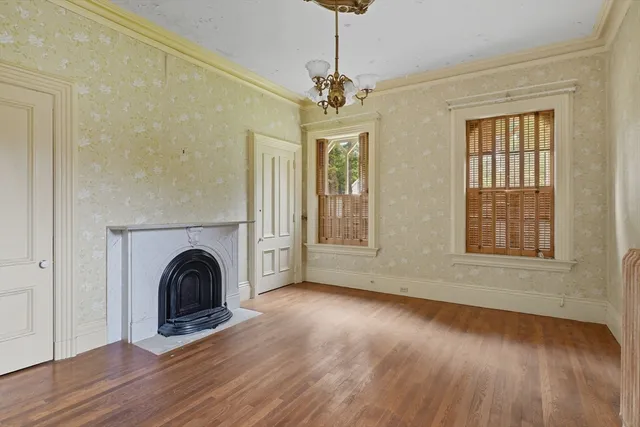 a view of empty room with fireplace and wooden floor