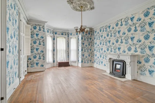 a view of a livingroom with a fireplace wooden floor and a chandelier