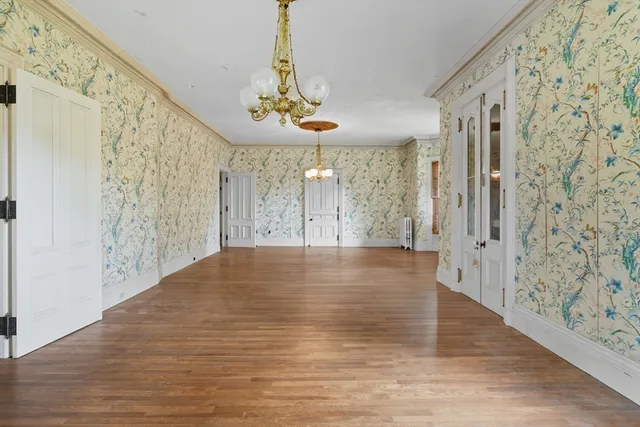 a view of a hallway with wooden floor and a chandelier
