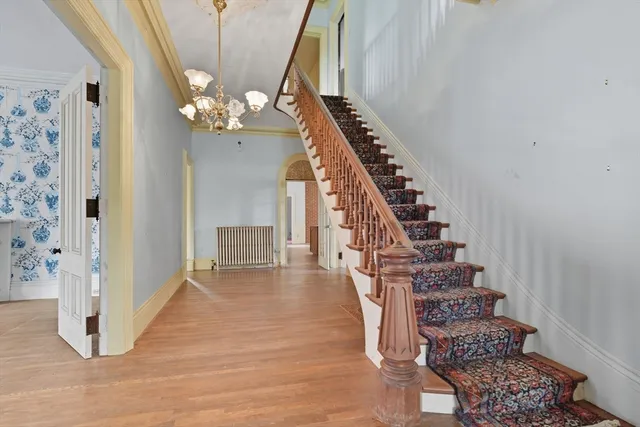 a view of a hallway with wooden floor and staircase