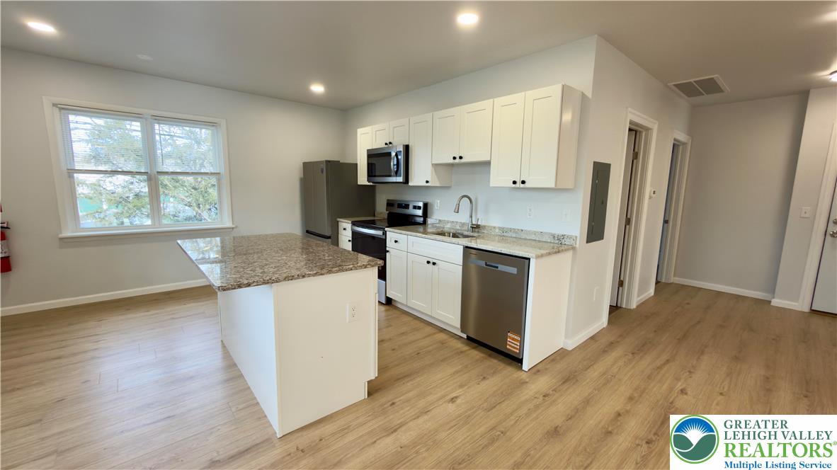 403 North Walnut Street, Unit B Bath, PA 18014 - Photo 6 of 31 a kitchen with stainless steel appliances granite countertop a stove top oven a refrigerator a sink and dishwasher with wooden floor