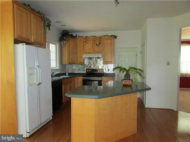 a kitchen with stainless steel appliances granite countertop a sink a refrigerator and a stove