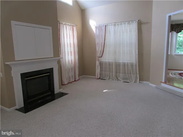 a view of empty room with fireplace and wooden floor