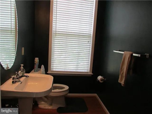 a bathroom with a sink toilet and a mirror