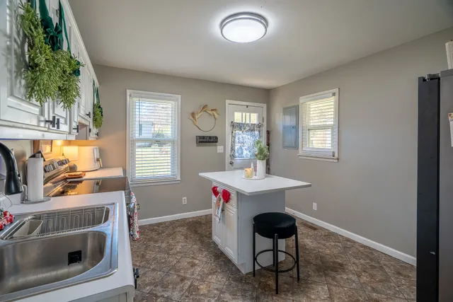 a view of kitchen with stainless steel appliances granite countertop sink stove and microwave
