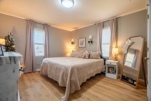 a bedroom with a bed a mirror and a window