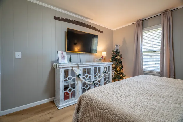 a bedroom with a bed and a flat screen tv