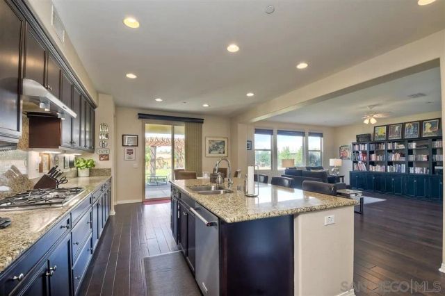 a kitchen with stainless steel appliances granite countertop a sink stove and cabinets