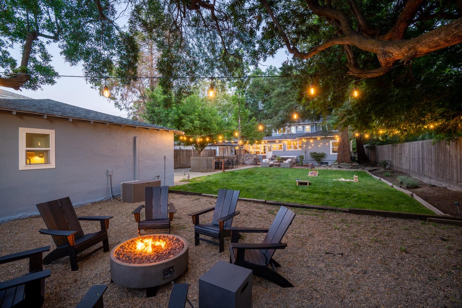 333 West Locust Street Lodi, CA 95240 - Photo 13 of 32 a view of a backyard with table and chairs and a barbeque with potted plants and large trees