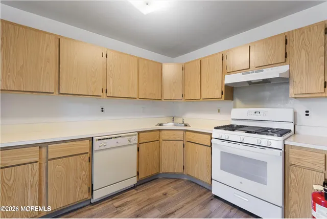 a kitchen with cabinets appliances a sink and a counter space