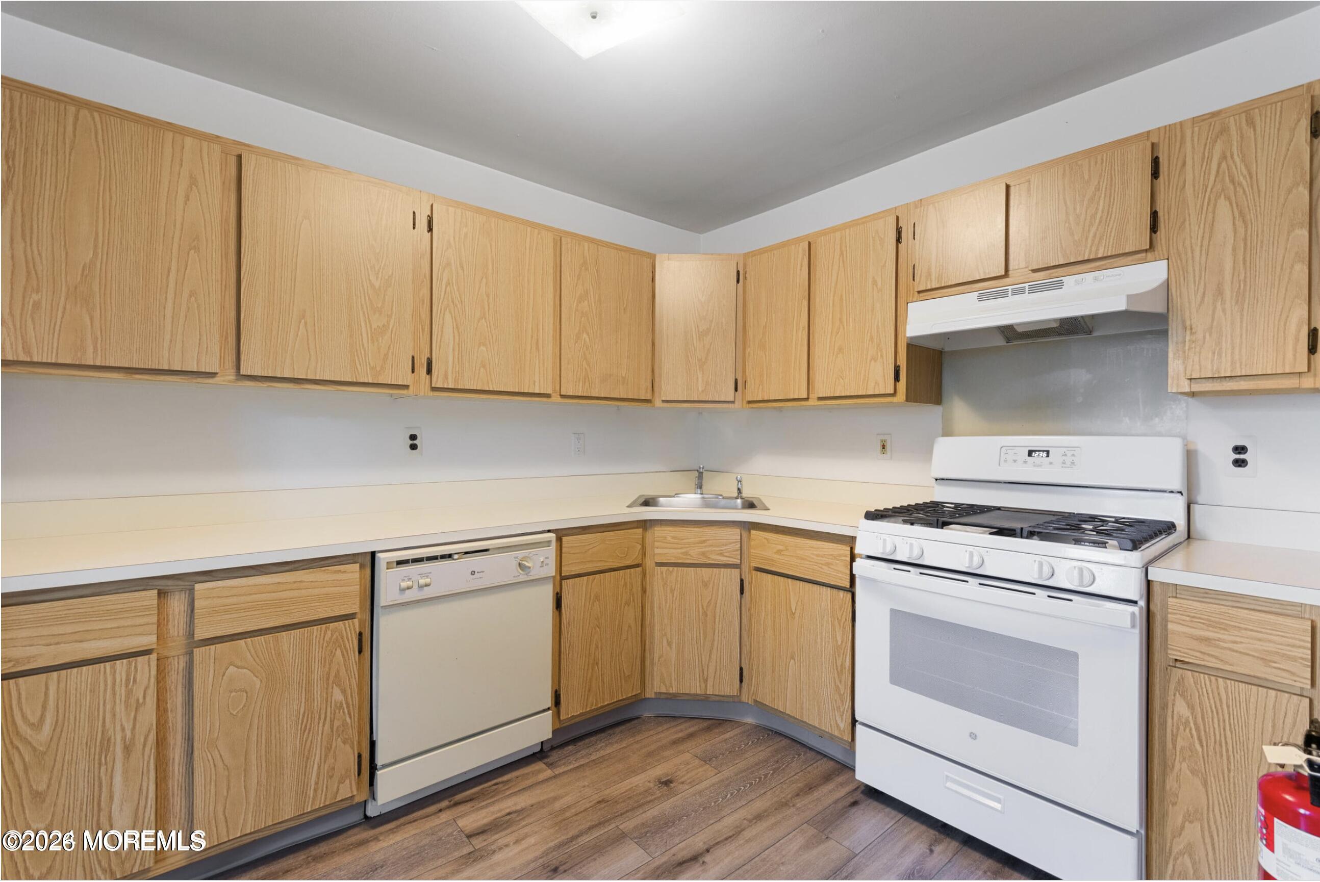 1606 Main Street, Unit R209 Lake Como, NJ 07719 - Photo 8 of 26 a kitchen with cabinets appliances a sink and a counter space