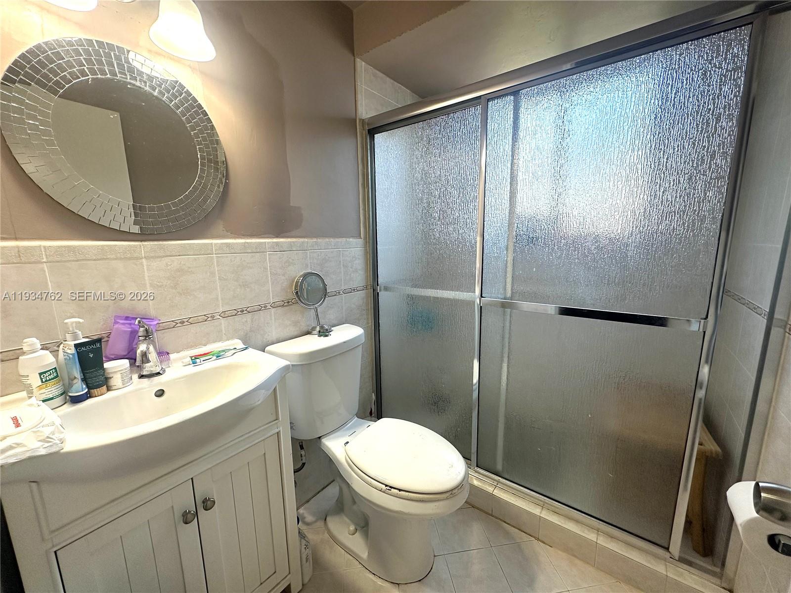 4361 Southwest 3rd Street Miami, FL 33134 - Photo 13 of 24 a bathroom with a sink mirror vanity and toilet
